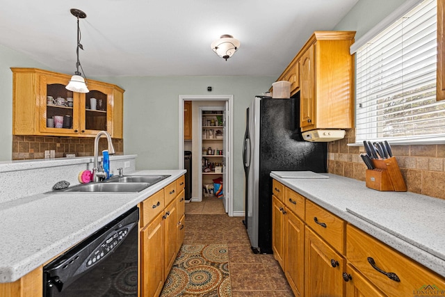 kitchen featuring dishwasher, sink, hanging light fixtures, and backsplash