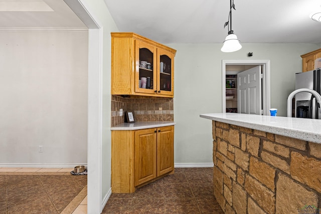 kitchen featuring dark tile patterned flooring, decorative light fixtures, stainless steel fridge, and decorative backsplash