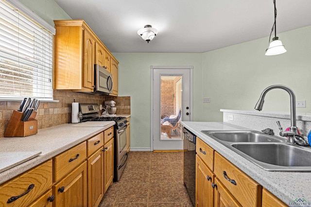 kitchen with pendant lighting, sink, backsplash, and stainless steel appliances