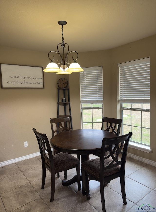 dining room with tile patterned floors, a chandelier, and baseboards