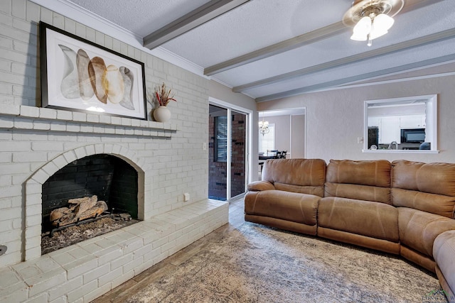 living room featuring beamed ceiling, a textured ceiling, an inviting chandelier, and a brick fireplace