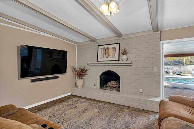 living room with beam ceiling, a fireplace, dark hardwood / wood-style flooring, and a textured ceiling