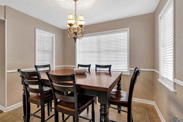 dining space featuring light tile patterned floors, a textured ceiling, and an inviting chandelier