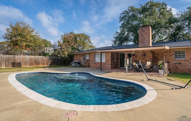 view of swimming pool featuring ceiling fan and a patio