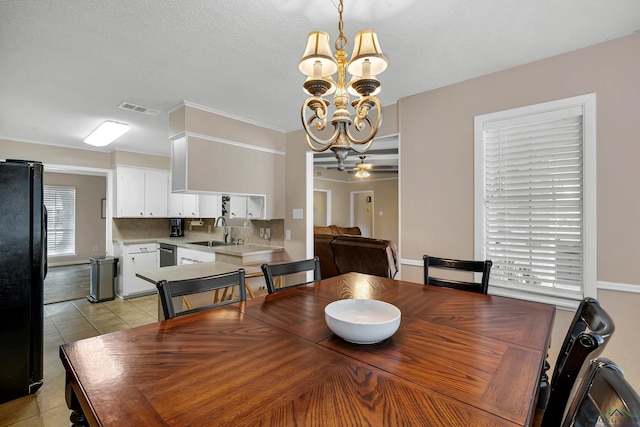 dining area with sink, light tile patterned flooring, ceiling fan with notable chandelier, and ornamental molding