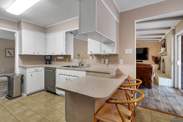 kitchen with white cabinetry, a kitchen bar, kitchen peninsula, and sink