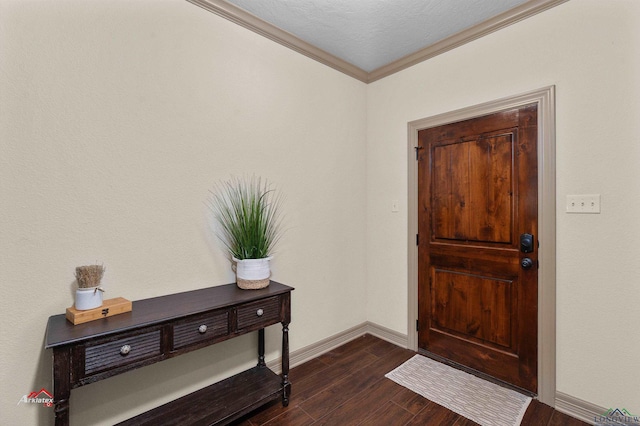 foyer entrance featuring a textured ceiling, ornamental molding, and dark wood-type flooring