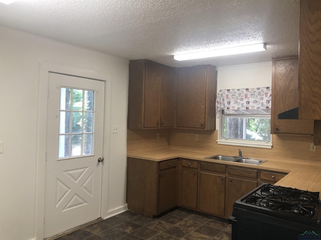 602 Premier Rd, Longview, TX 75604 - kitchen featuring a sink, black gas range, light countertops, a textured ceiling, and tasteful backsplash