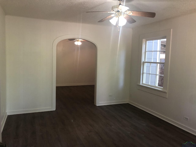 602 Premier Rd, Longview, TX 75604 - unfurnished room featuring arched walkways, dark wood-type flooring, a textured ceiling, ceiling fan, and baseboards