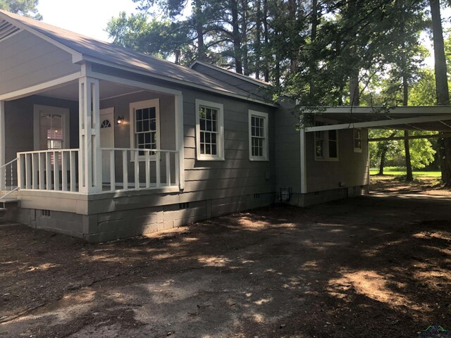 602 Premier Rd, Longview, TX 75604 - view of side of property featuring crawl space, an attached carport, driveway, and covered porch
