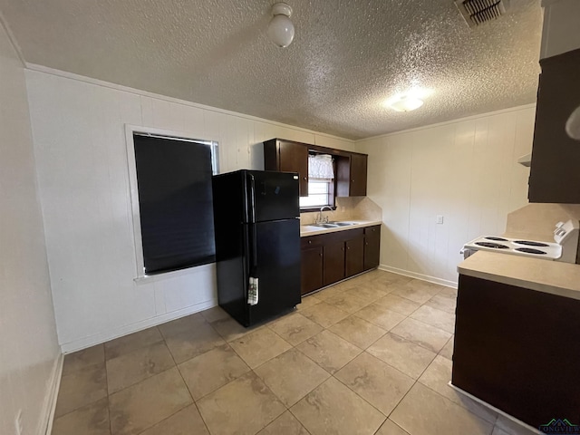 kitchen with black fridge, dark brown cabinets, sink, light tile patterned floors, and range with electric stovetop