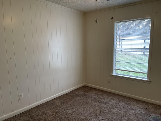 carpeted spare room featuring wood walls