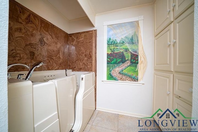 clothes washing area featuring light tile patterned floors and crown molding