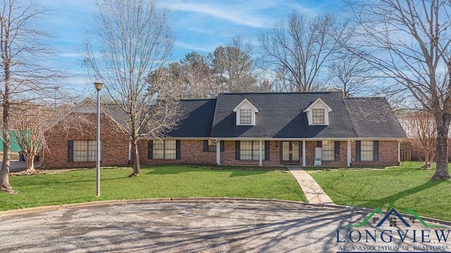 new england style home featuring a front yard