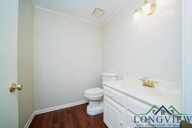 bathroom featuring crown molding, vanity, wood-type flooring, and toilet