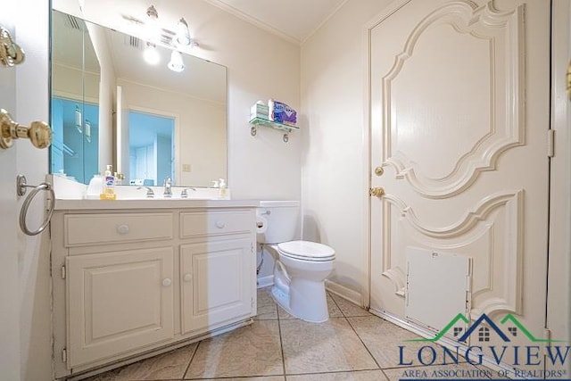 bathroom with toilet, vanity, tile patterned floors, and crown molding