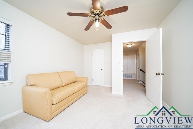 carpeted living room with ceiling fan and baseboard heating