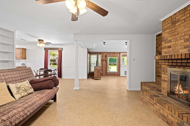 living room with ceiling fan, a fireplace, and ornamental molding