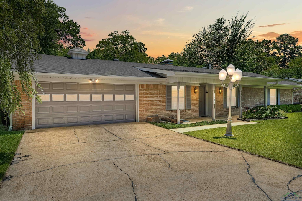 single story home with a lawn and a garage