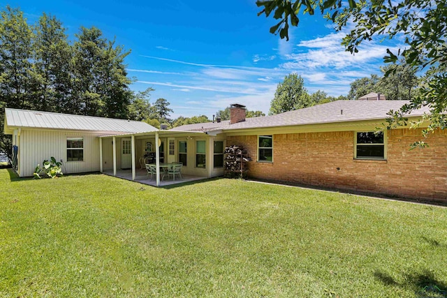 rear view of house with a patio area and a yard