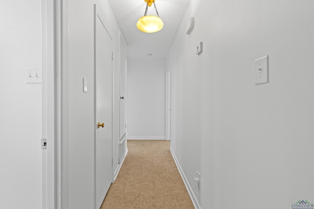 hall featuring light colored carpet