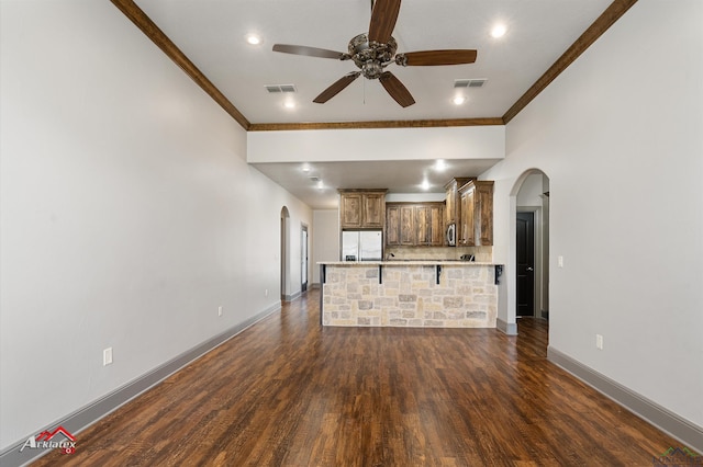 unfurnished living room featuring ceiling fan, dark hardwood / wood-style floors, and crown molding