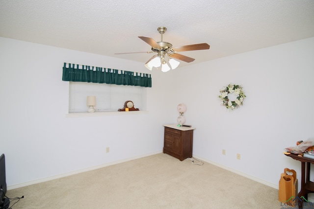 carpeted empty room with ceiling fan and a textured ceiling