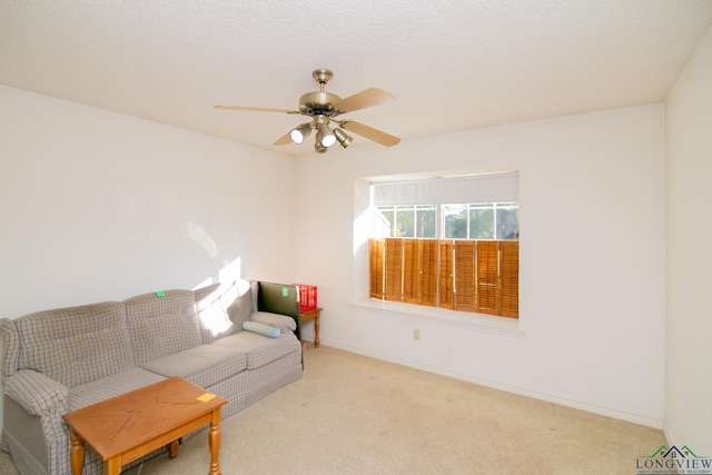 living room featuring ceiling fan, light colored carpet, and a textured ceiling