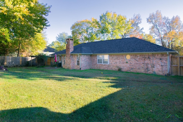 rear view of property featuring a yard