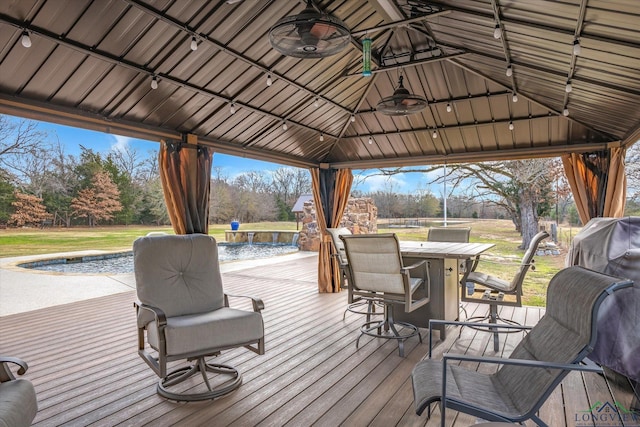 deck with pool water feature, a gazebo, exterior bar, and ceiling fan