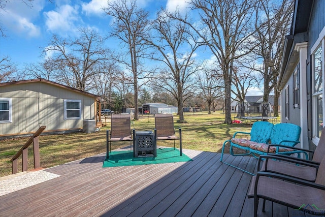 deck featuring a trampoline and a yard