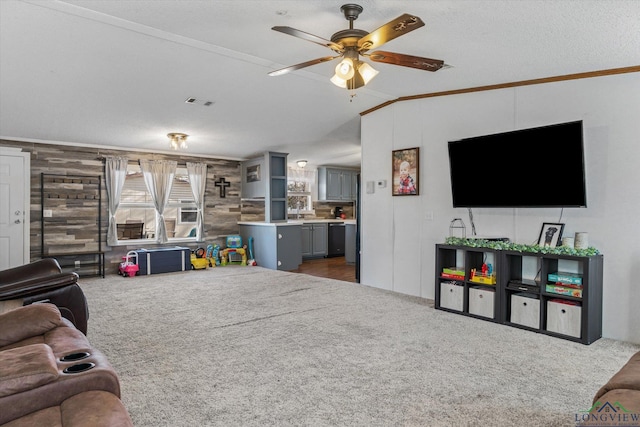 living room featuring a textured ceiling, ceiling fan, ornamental molding, and wood walls