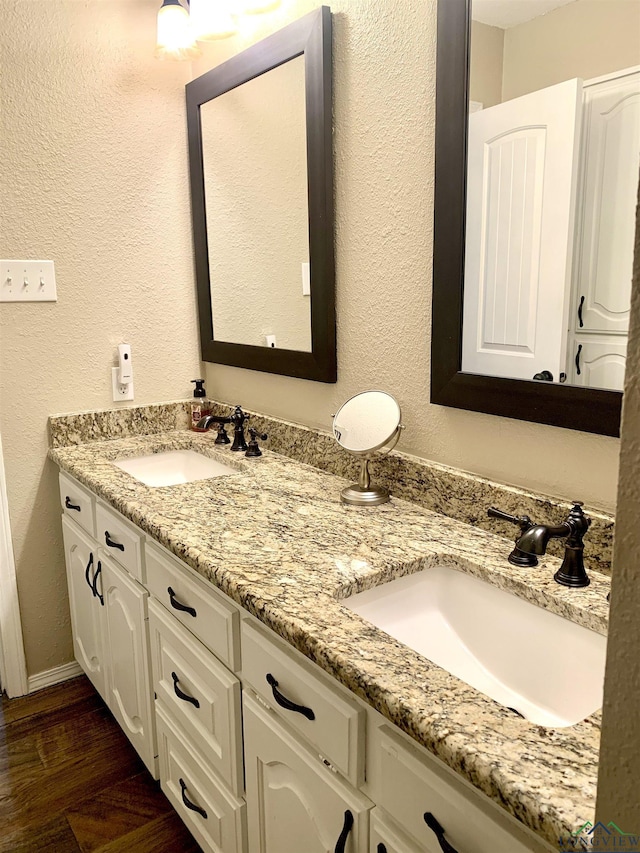 4401 Leland St, Marshall, TX 75672 - full bathroom with double vanity, wood finished floors, and a textured wall