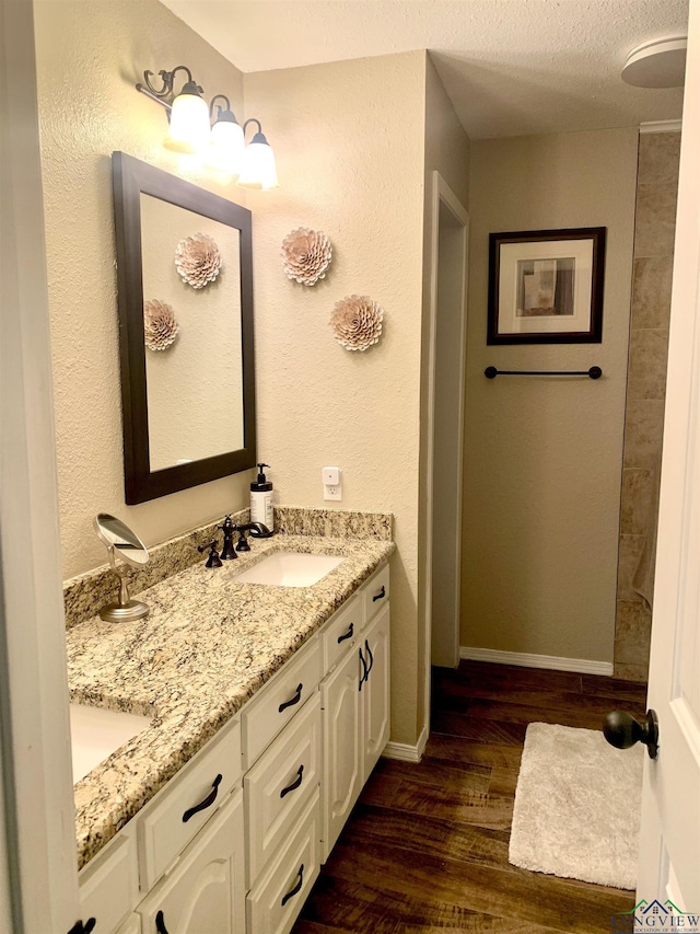 4401 Leland St, Marshall, TX 75672 - bathroom with wood finished floors, double vanity, and a textured ceiling
