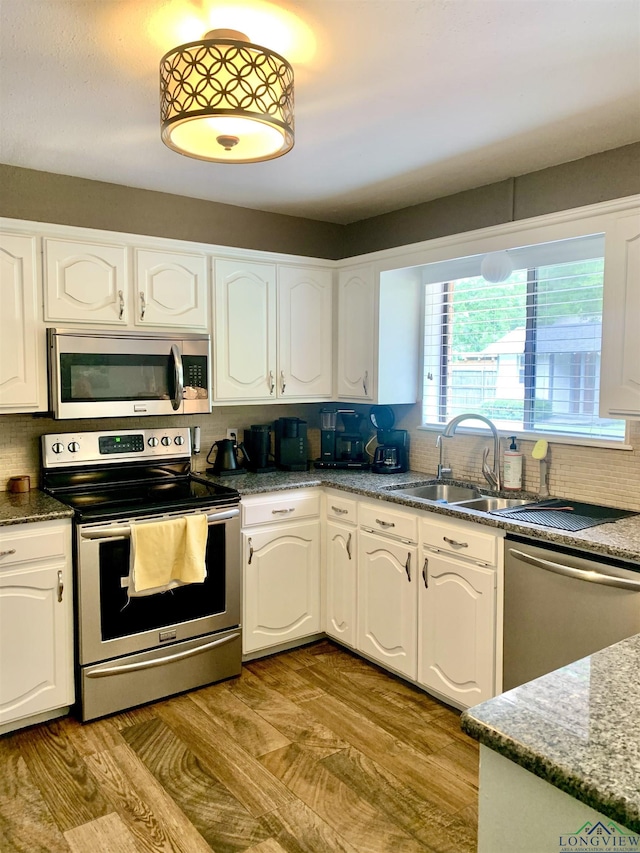 4401 Leland St, Marshall, TX 75672 - kitchen featuring stainless steel appliances, backsplash, white cabinetry, and dark stone counters