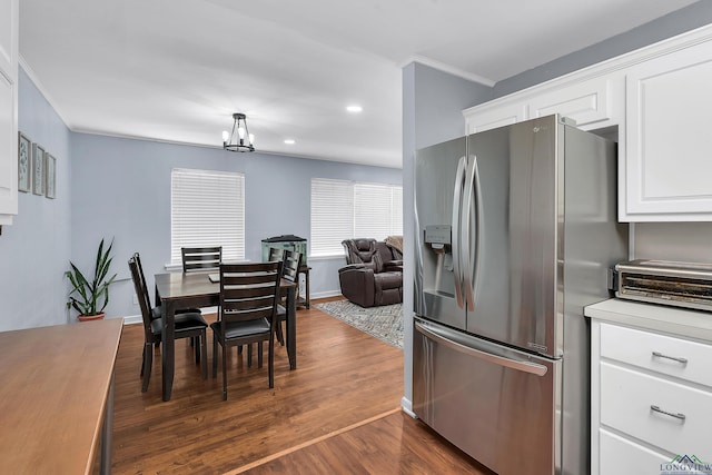 kitchen featuring stainless steel refrigerator with ice dispenser, dark wood-style flooring, crown molding, recessed lighting, and white cabinetry
