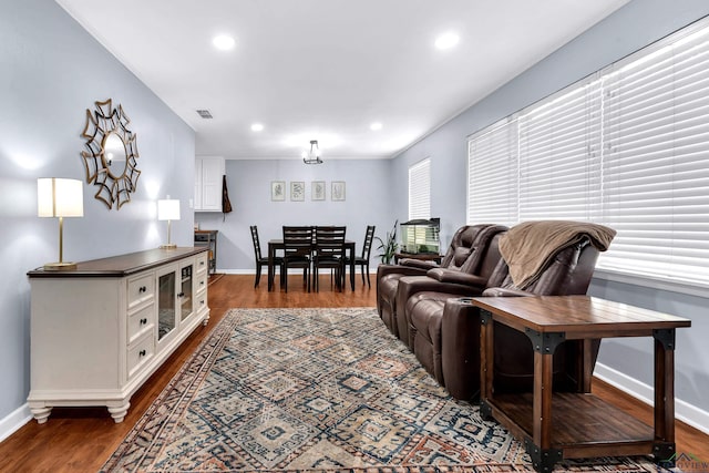 living area featuring baseboards, dark wood-type flooring, and recessed lighting