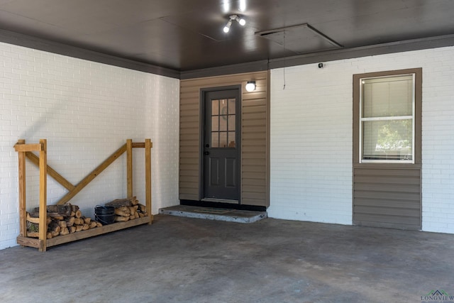 entrance to property featuring brick siding