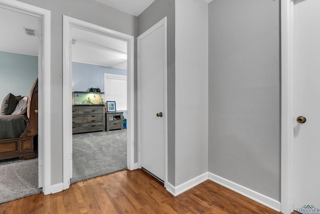 corridor featuring wood finished floors and baseboards