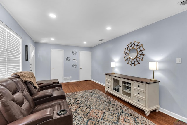 living area featuring dark wood-type flooring, baseboards, and recessed lighting