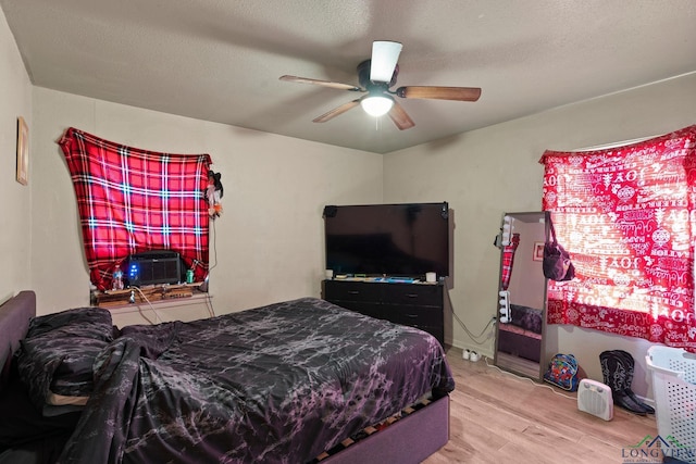 bedroom featuring wood-type flooring, ceiling fan, and a textured ceiling