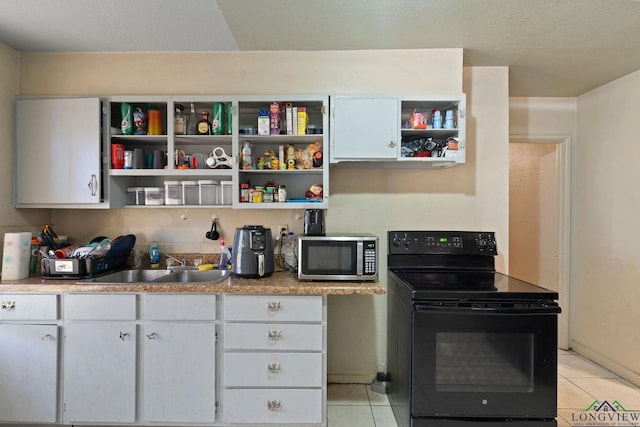 kitchen with black range with electric stovetop, sink, white cabinets, and light tile patterned flooring