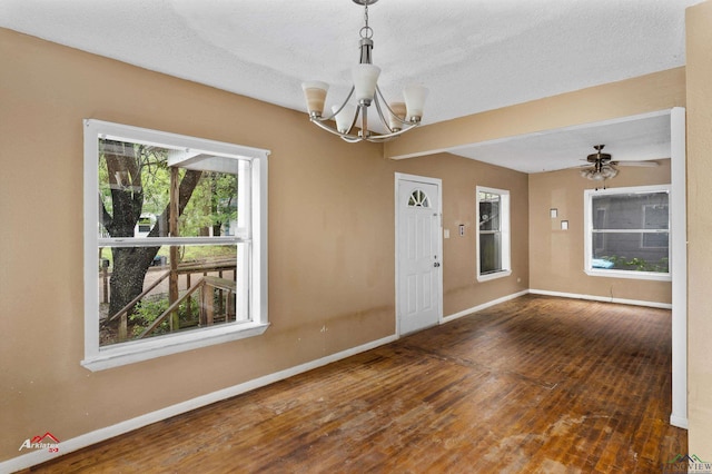 interior space with dark hardwood / wood-style flooring, ceiling fan with notable chandelier, and a textured ceiling