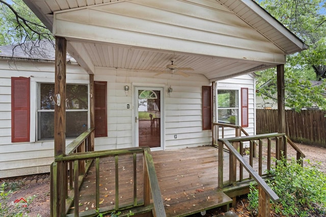 view of exterior entry featuring ceiling fan and a wooden deck