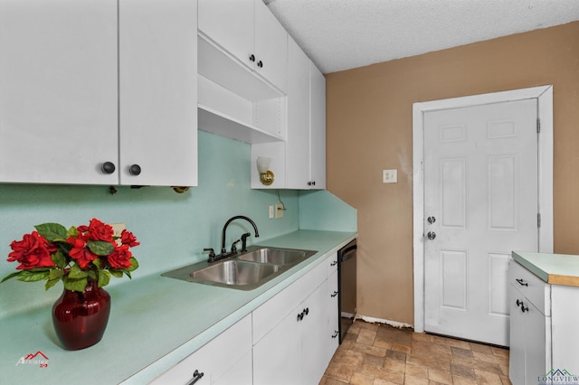 kitchen with white cabinetry, sink, dishwasher, and a textured ceiling