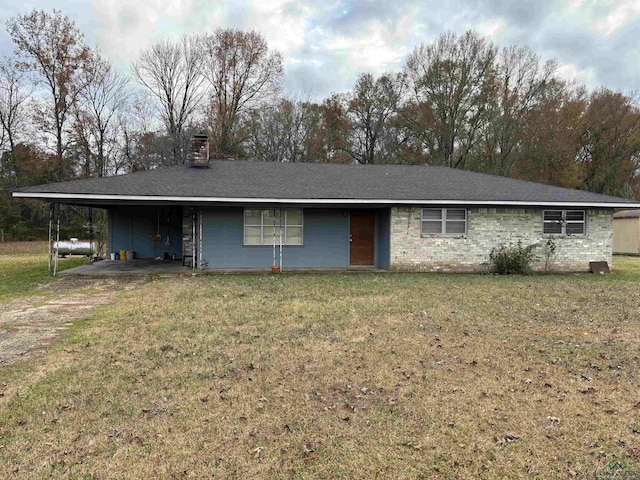 single story home with a chimney, a front lawn, and an attached carport