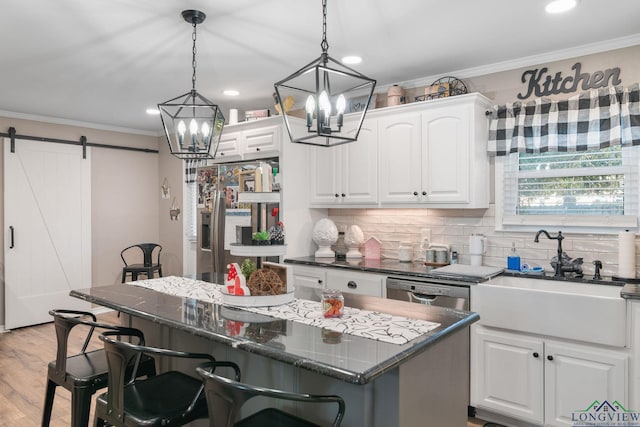 kitchen with white cabinetry, a center island, and a barn door