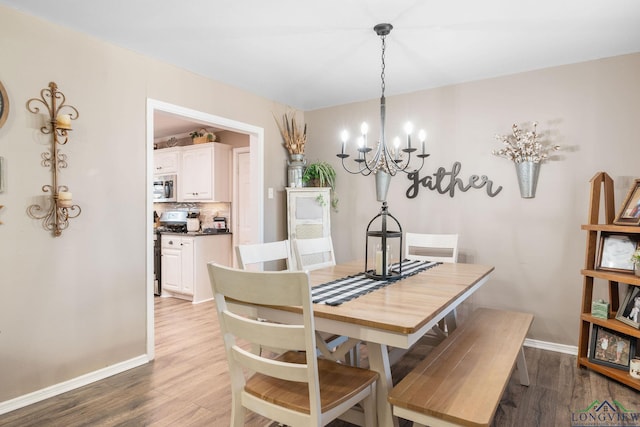 dining space featuring wood-type flooring and a chandelier