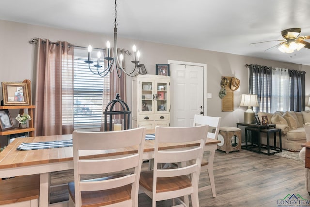 dining room featuring ceiling fan with notable chandelier and hardwood / wood-style floors