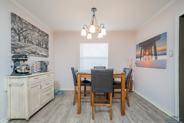 dining room featuring ornamental molding, light wood-type flooring, and an inviting chandelier